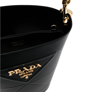 Planet Luxury Brands imzalı, altın tonlu metal logolu ve kapitone detaylı siyah deri Prada kova çanta
