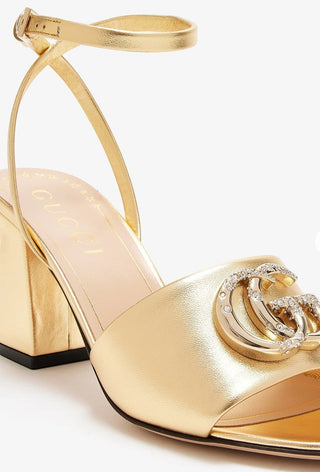 Planet Luxury Brands altın rengi metalik deri, taşlı GG logolu ve 7.5 cm topuklu kadın sandalet