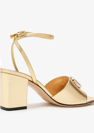 Planet Luxury Brands imzalı, GG taşlı logolu, 7.5 cm topuklu, altın rengi metalik deri Gucci kadın sandalet.