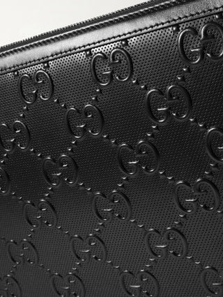 Planet Luxury Brands imzalı, ikonik GG logolu siyah kabartmalı deri Gucci el çantası detayı.