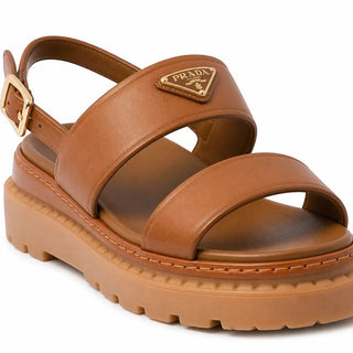 Planet Luxury Brands imzalı, metal logolu, kahverengi deri, kalın kauçuk tabanlı şık kadın sandalet.