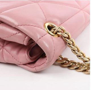 Planet Luxury Brands pembe deri kapitone omuz çantası, altın tonlu zincir askı ve üçgen logo detayı ile.