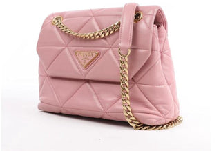 Planet Luxury Brands pembe deri omuz çantası, altın tonlu zincir askı ve üçgen logo detaylı, İtalya üretimi.