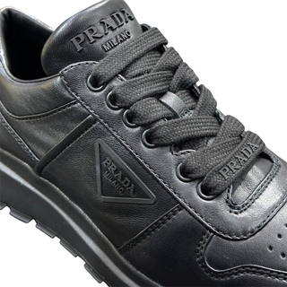 Planet Luxury Brands siyah deri Prada kadın sneaker, yan kısımda logo detayı ve bağcıklı tasarım.