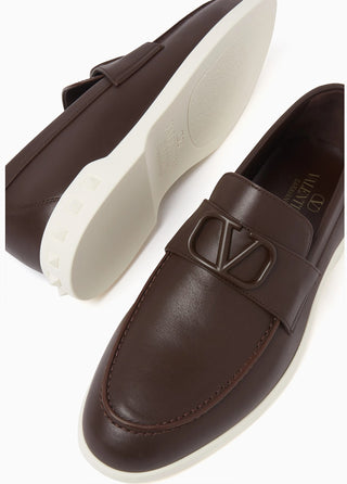 Planet Luxury Brands Valentino Garavani kahverengi deri erkek loafer, ön kısımda V logo toka ve beyaz taban detaylı