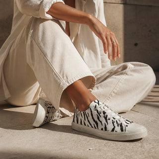 Planet Luxury Brands zebra desenli, beyaz kanvas günlük spor ayakkabı giyen kadın